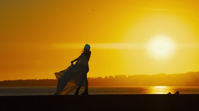 Dancer performs at sunset by the water in a beautiful display of movement and grace
