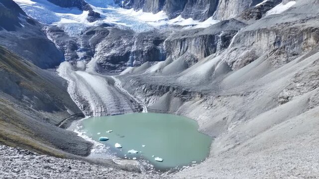Immense Icy Amphitheater Hosting Sparkling Lake Amid Rugged Rocky Cliffs With Peaceful Summer Light