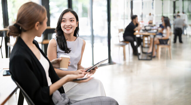 Asian Businesswomen Having Informal Meeting Over Coffee in Modern Office