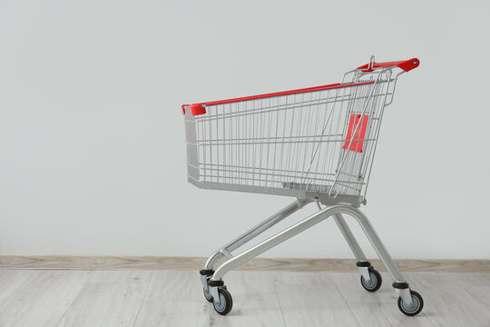 Shopping cart near grey wall