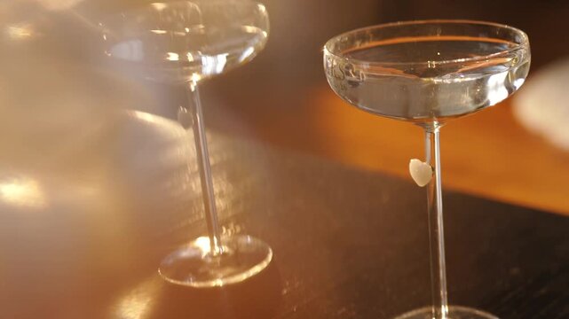 A loving couple on a date drinking an alcoholic cocktail near a fireplace. A man and a woman are having a romantic dinner. A close-up of a glass goblet of champagne. Sparkling wine with reflections