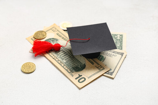 Graduation hat with money on white background. Tuition fees concept