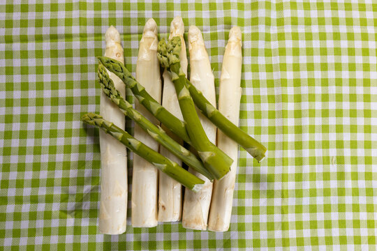 Spargel Wei&szlig; und gr&uuml;n auf einer gemusterten Tischdecke 