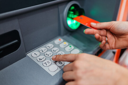 Entering PIN code to access personal bank account in ATM. Concept protection and privacy.