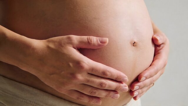 Pregnant belly with hands gently holding