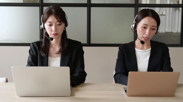 ノートパソコンを見ながら対応をするコールセンターの女性