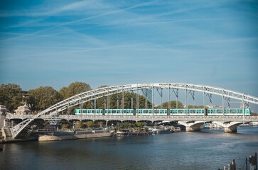 Fototapeta premium A vibrant train moves across a sleek bridge, connecting communities in Blois as the Loire River flows below. The scene captures the essence of accessibility amidst ongoing environmental concerns