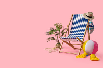 Deck chair with beach accessories on pink background © Pixel-Shot