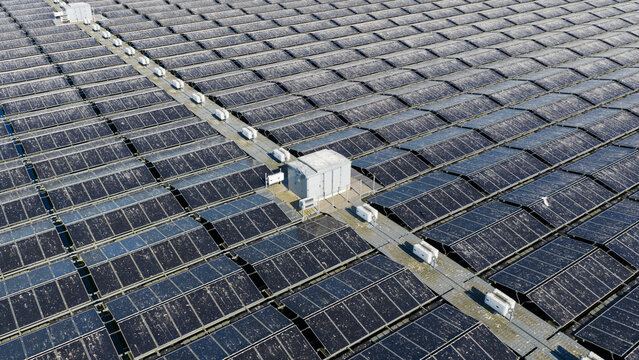 Aerial view of the floating solar panels at Sekdoornse Plas solar farm with electrical inverters and walkways on the water in Zwolle, Overijssel, Netherlands.