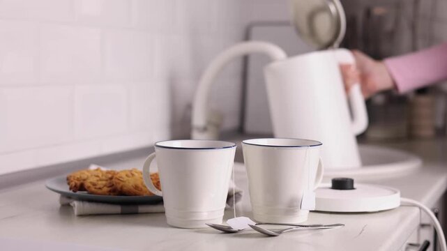 Pure water boils in an electric kettle on the table in the kitchen