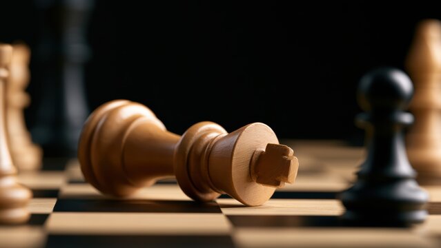 A majestic white king lies defeated on the chessboard, symbolizing the end of a challenging strategic game.