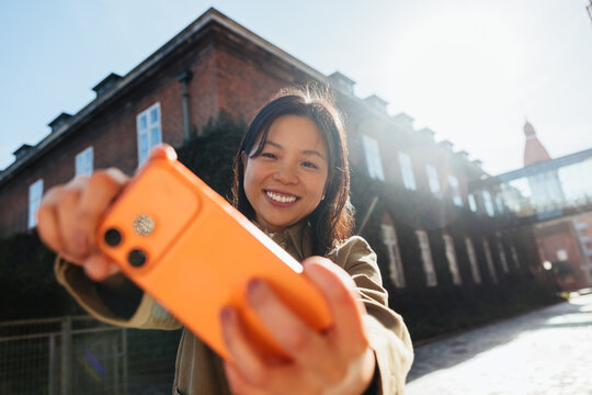 Young woman taking a smartphone selfie outdoors