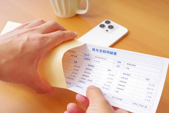 給料日に給与明細を確認する男性の手元