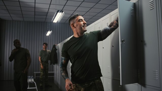 Three Diverse Athletic Soldiers in Military Uniforms Undress by Lockers, Friendly Interacting and Chatting After Successfully Finishing Mission or Duty. Concept of Shift End on Modern Military Base.