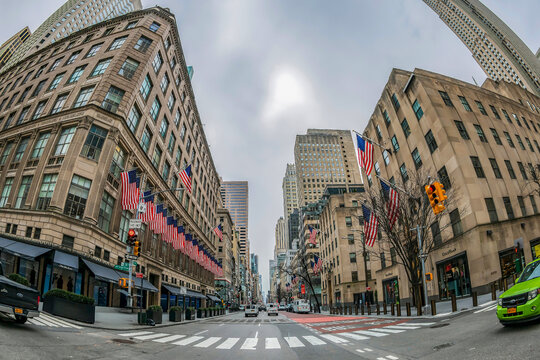 NEW YORK, USA-MARCH 7, 2020:Old commercial building decorated with American flags,located in Manhattan,on 5th Avenue at the intersection with E 50 St,near St. Patrick Cathedral and Rockefeller Center.