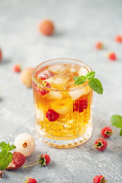 Lychee raspberry iced tea with mint leaves in glass. Summer drink