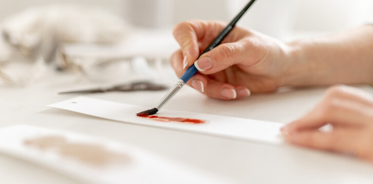 Close-Up Of A Woman's Hand Painting With Watercolors