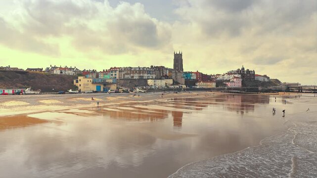 Seaside views of the holiday town of Croma on the Norfolk coast. Sandy beach and sea. Holiday destination, vintage photograph. North Sea coastline, Chapel, church and pier on the promenade, tourists.