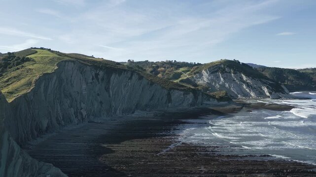 Majestic aerial view of the flysch geological formations on the Basque coast at Sakoneta beach in Zumaia, a unique natural landscape with cliffs and a beautiful sea under a clear sky