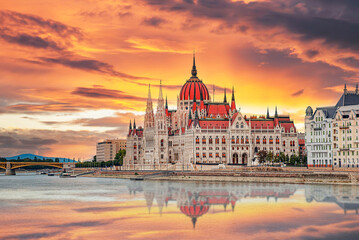The Hungarian Parliament Building stands prominently along the Danube River under a vibrant sunset sky in Budapest. © Denis Rozhnovsky