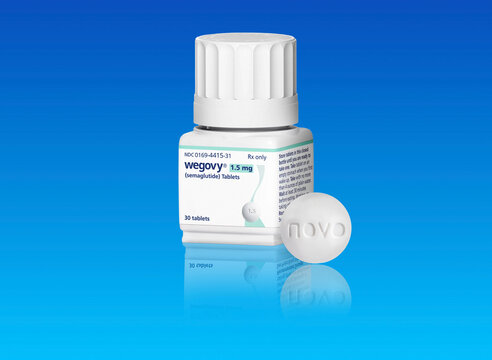 Studio shot of bottle of Wegovy weight loss drug  with pill from Novo Nordisk on blue background with copy space. Copenhagen, Denmark - May 1, 2026..
