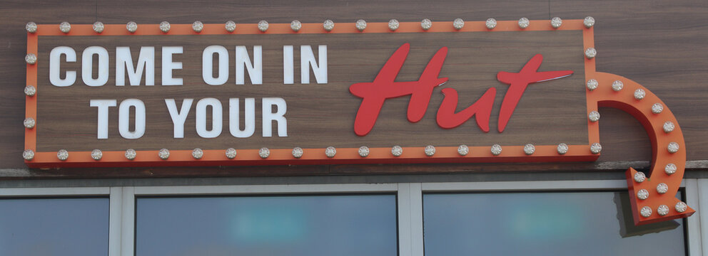 Norwich, England: April 11 2026. Inviting neon sign lights up a welcoming entrance to your hut with warm cozy atmosphere