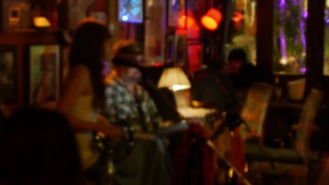 Blurred defocused live music jazz band performance inside cozy vintage bar with warm golden red bokeh ambiance nightlife