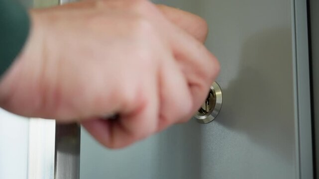 Hand turning key to lock door in home close up of security action showing protection privacy and safety in modern apartment interior. High quality 4k footage