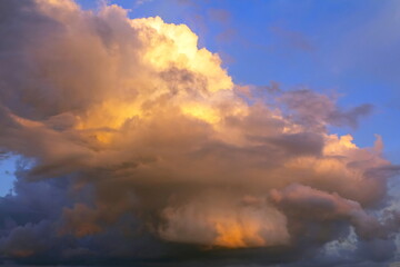 Fototapeta premium beautiful cumulus clouds illuminated by the sun at sunset on a summer day