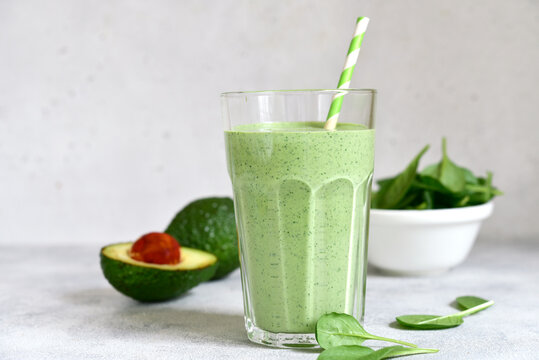 Detox avocado spinach smoothie in a tall glass. Top view with copy space.