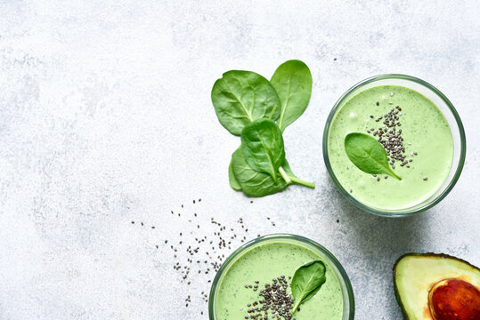 Detox avocado spinach smoothie in a tall glass. Top view with copy space.