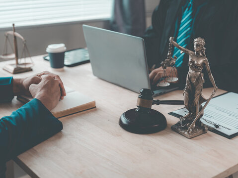 The lawyer advised his client on contractual documents, using a brass scale to explain legal points in court.