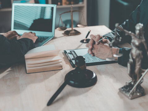 The lawyer advised his client on contractual documents, using a brass scale to explain legal points in court.