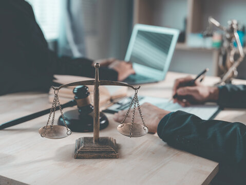 The lawyer advised his client on contractual documents, using a brass scale to explain legal points in court.