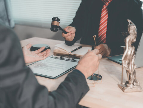 The lawyer advised his client on contractual documents, using a brass scale to explain legal points in court.