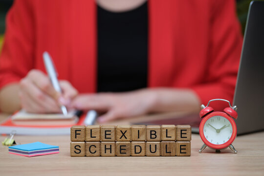 Working diligently at a desk, a person uses a notebook and pen while emphasizing the importance of a balanced and flexible work schedule. A clock ticks nearby, adding urgency.