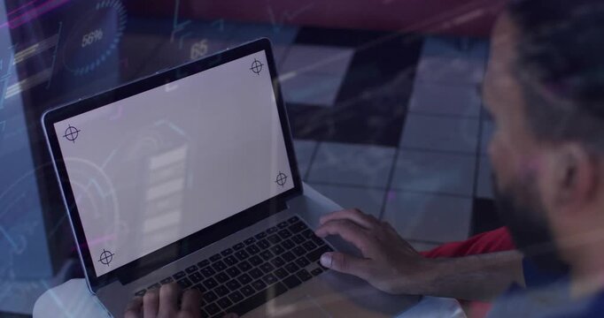 Man sitting at table, tapping trackpad while starting HUD for UI mockup showing crop marks