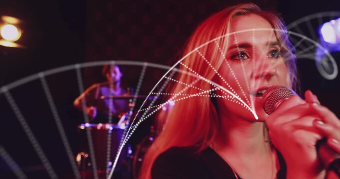 Camera pulling back revealing singer gripping mic performing song as dotted arcs sweeping over her