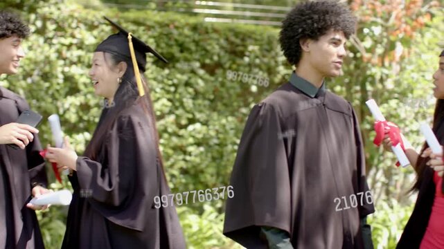 Male graduate conversing as peers approaching and exchanging diplomas at graduation with watermarks