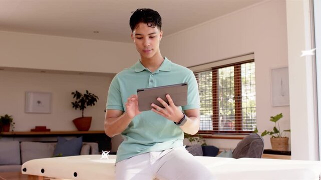 Man sitting tapping tablet in home teal frames popping, sparks on hands marking health app