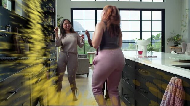 Redhead woman reaching counter causing yellow swirl, three women dancing to celebrate in kitchen