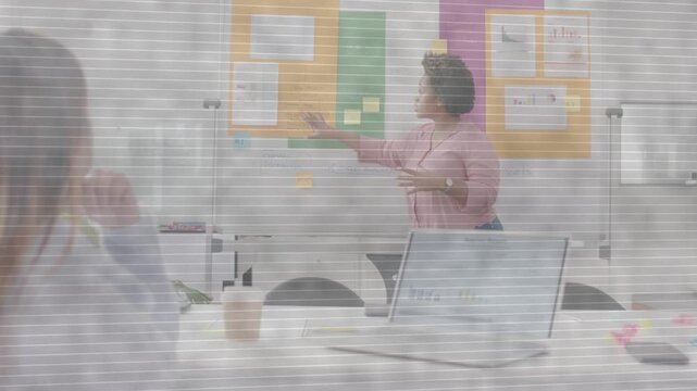 Presenter pointing whiteboard notes, gesturing, explaining strategy in business workshop