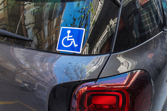 Wheelchair accessibility disabled sign sticker on a car window.