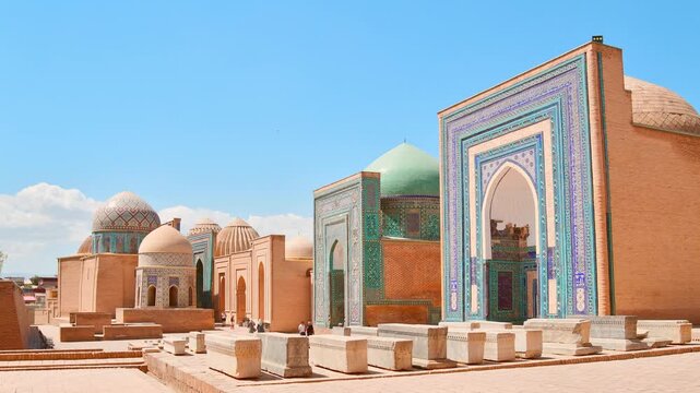 Day time timelapse of Shah i Zinda necropolis in Samarkand. Visitors explore the stunning blue-tiled mausoleums and turquoise domes of historic UNESCO Silk Road landmark.