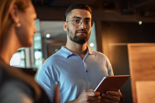 Confident professional holding tablet in modern office