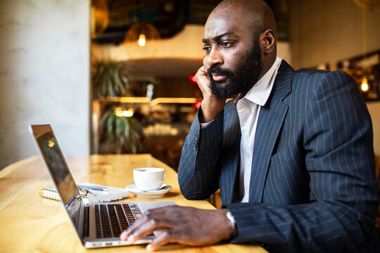 Focused businessman working on laptop in cafe