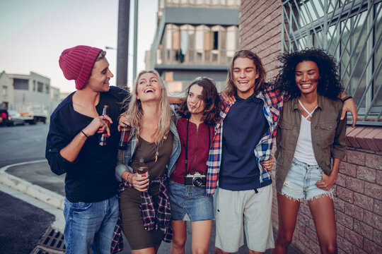 Group of young friends laughing together on city street
