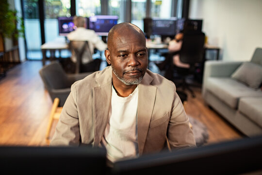 Middle-aged man working at computer in modern office