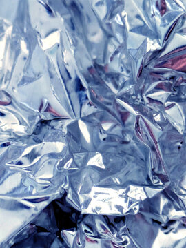 Shiny crumpled abstract silver foil close up background