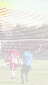 Vertical video: Adult soccer player running into goal area trying to score, keeper diving